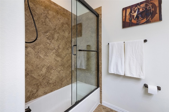 bathroom with enclosed tub / shower combo and baseboards