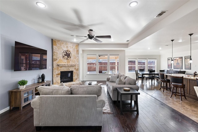 living room featuring ceiling fan, recessed lighting, a fireplace, visible vents, and dark wood finished floors