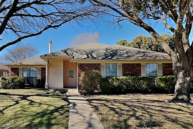 single story home featuring brick siding and a front yard