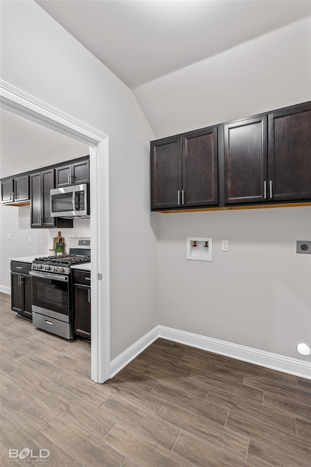 kitchen with baseboards, appliances with stainless steel finishes, and wood finished floors