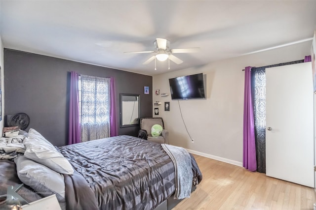 bedroom featuring light wood-style floors, baseboards, and a ceiling fan