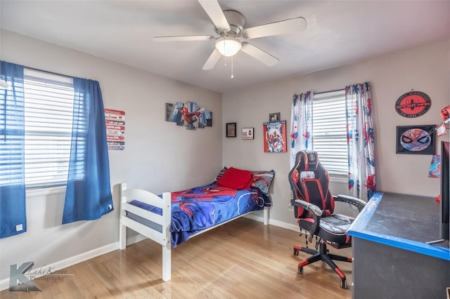 bedroom featuring wood finished floors, a ceiling fan, and baseboards