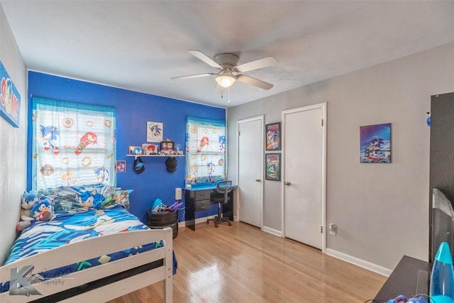 bedroom with baseboards, a ceiling fan, and light wood-style floors