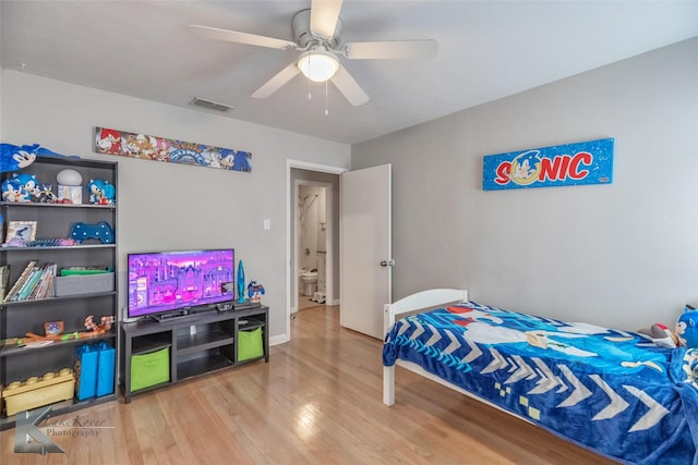 bedroom featuring ceiling fan, wood finished floors, visible vents, and baseboards