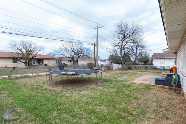 view of yard featuring a trampoline, a patio area, and a fenced backyard