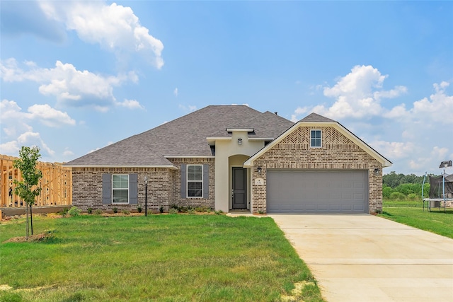 view of front of property with a garage, brick siding, concrete driveway, a trampoline, and a front yard