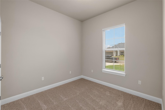 carpeted spare room with baseboards