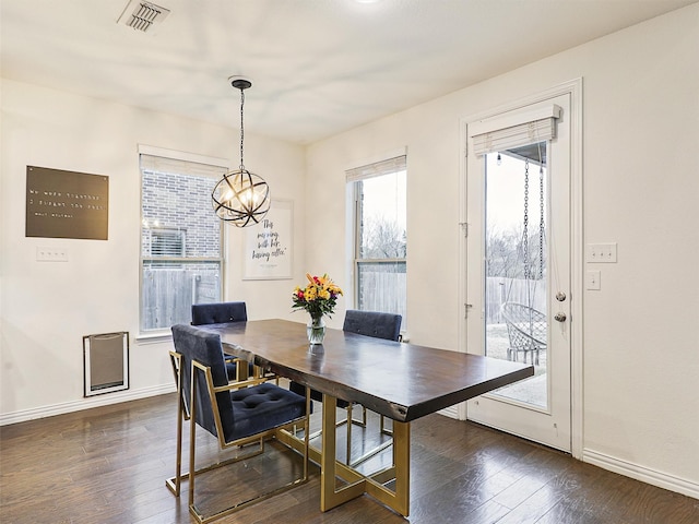 dining area with dark wood-style floors, a chandelier, visible vents, and baseboards