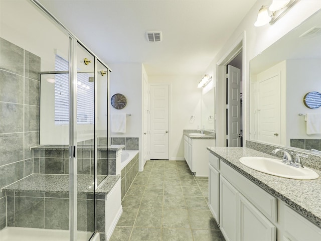 full bath featuring a garden tub, two vanities, a sink, visible vents, and a stall shower