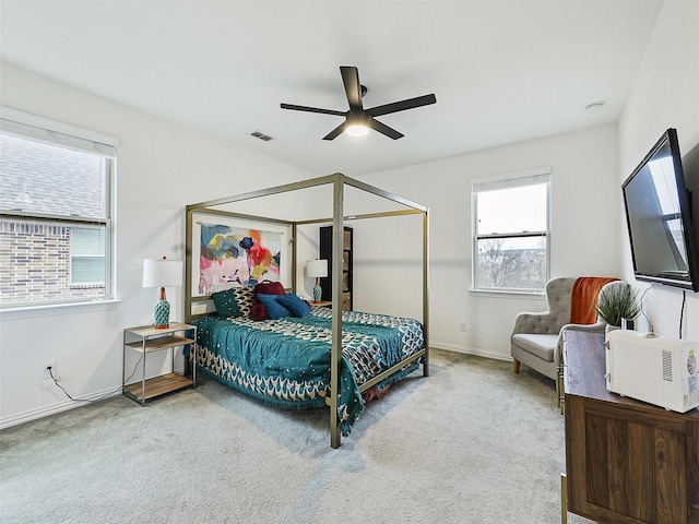 bedroom with a ceiling fan, light colored carpet, visible vents, and baseboards