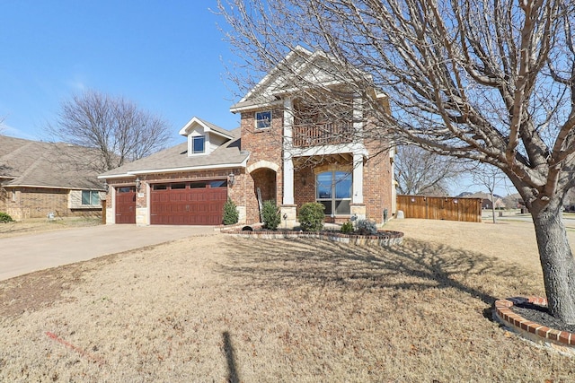 view of front of home with an attached garage, a balcony, brick siding, fence, and concrete driveway