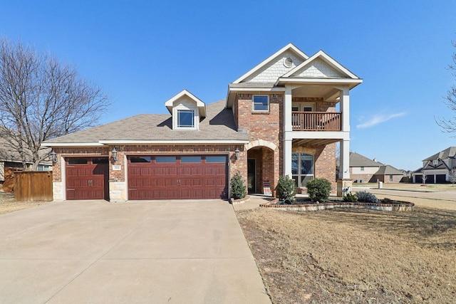 view of front of house featuring a garage, driveway, brick siding, and a balcony