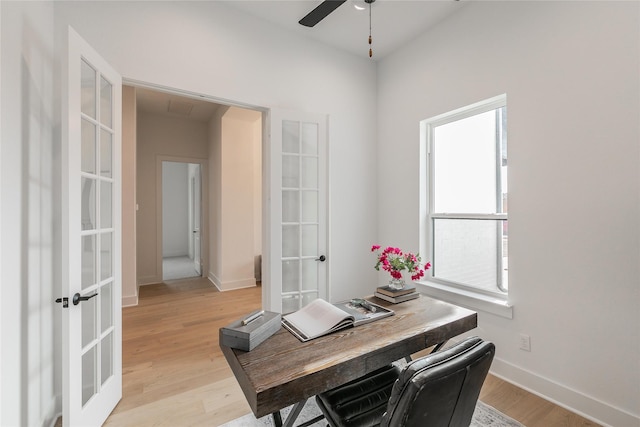 office area featuring light wood finished floors, baseboards, a ceiling fan, and french doors