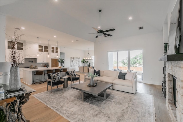 living room with light wood finished floors, a fireplace, visible vents, and recessed lighting