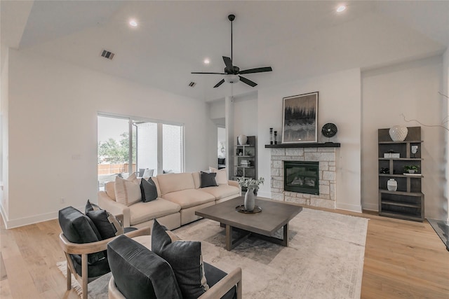 living room with light wood finished floors, a fireplace, visible vents, and baseboards