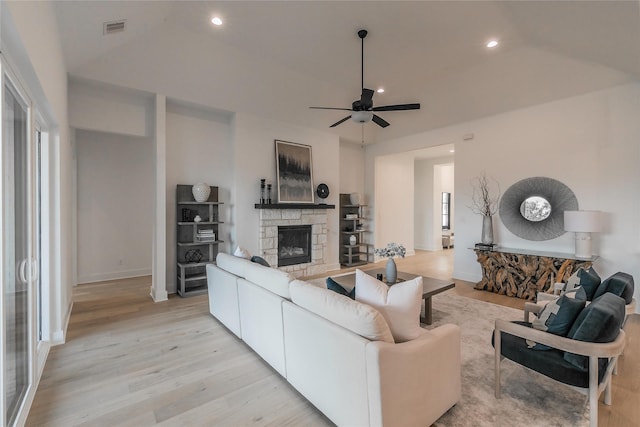 living area featuring a stone fireplace, light wood-style flooring, recessed lighting, a ceiling fan, and visible vents