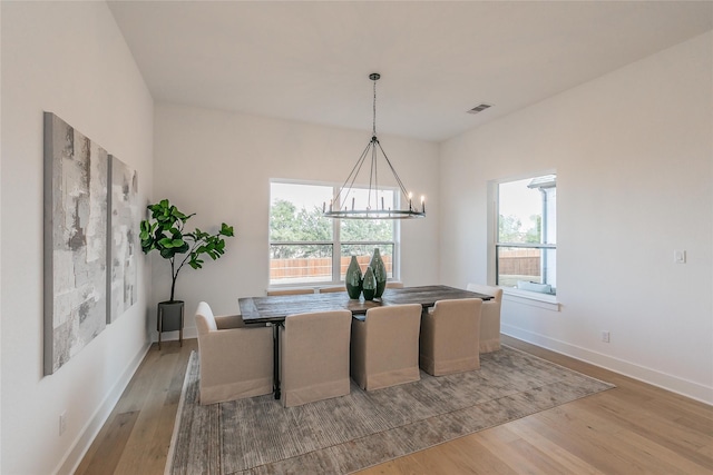 dining room featuring light wood-style flooring, visible vents, a chandelier, and a wealth of natural light