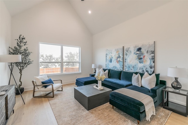 living area featuring baseboards, high vaulted ceiling, wood finished floors, and recessed lighting