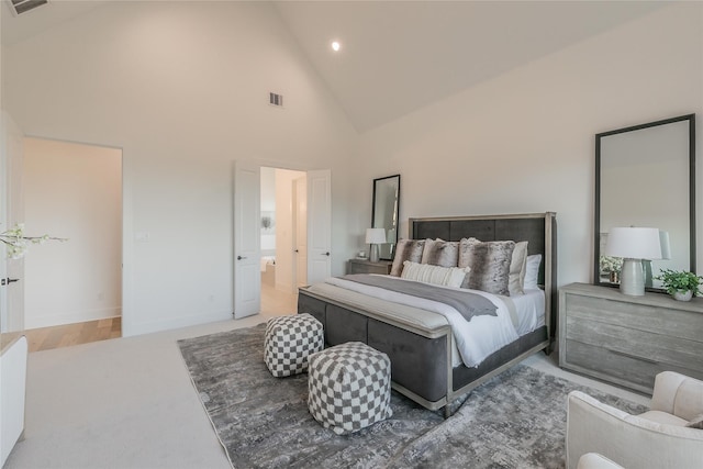 carpeted bedroom with high vaulted ceiling, visible vents, and baseboards