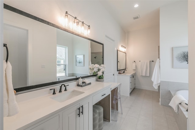 bathroom featuring two vanities, a sink, tile patterned flooring, and recessed lighting