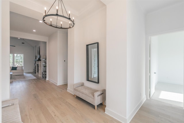 hallway with light wood-style flooring, baseboards, and crown molding