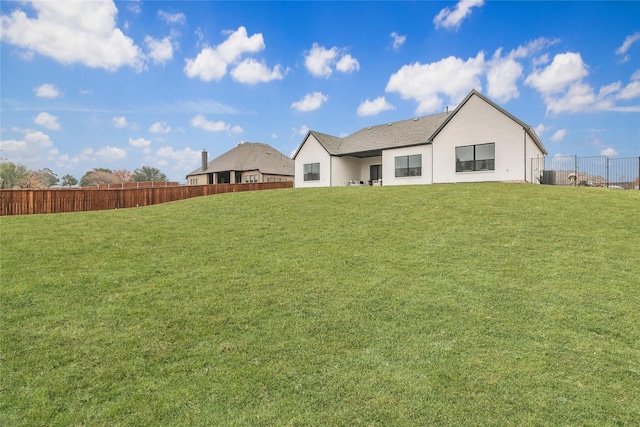 rear view of property with a yard and a fenced backyard