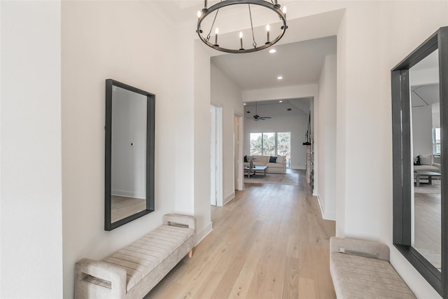 hallway featuring a chandelier, recessed lighting, light wood-style flooring, and baseboards