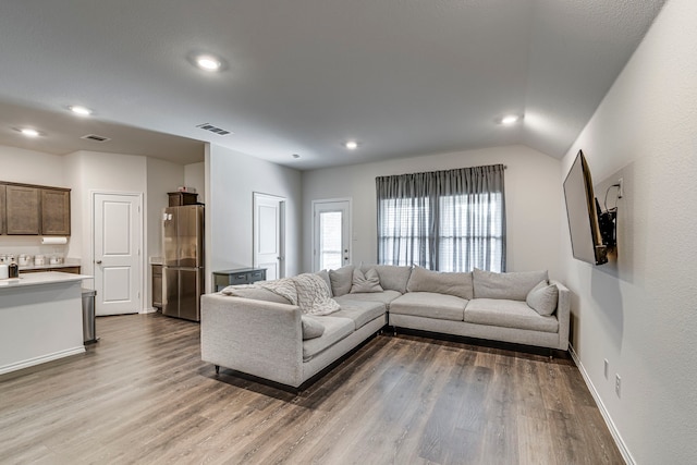 living area with recessed lighting, wood finished floors, visible vents, and baseboards