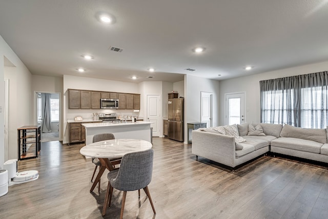 living room featuring recessed lighting, visible vents, and light wood finished floors