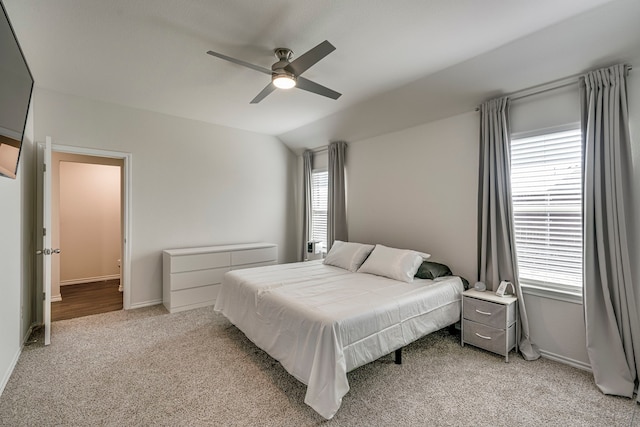 bedroom featuring light carpet, ceiling fan, vaulted ceiling, and baseboards