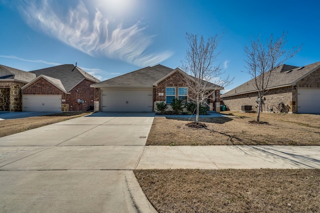 view of front of house featuring brick siding, central AC unit, concrete driveway, an attached garage, and a front yard