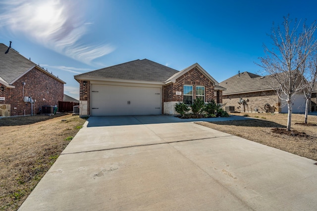 view of front of home featuring a garage, brick siding, driveway, and central air condition unit