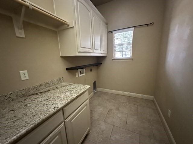 washroom with light tile patterned flooring, hookup for a washing machine, baseboards, cabinet space, and electric dryer hookup