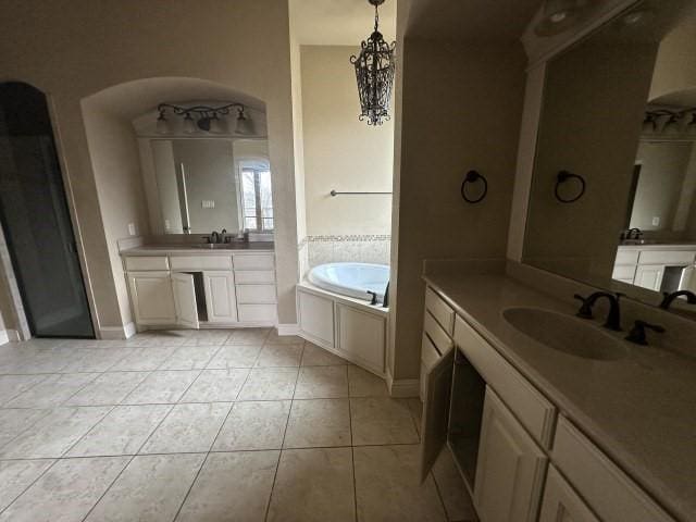 full bath with tile patterned flooring, two vanities, a sink, and a bath