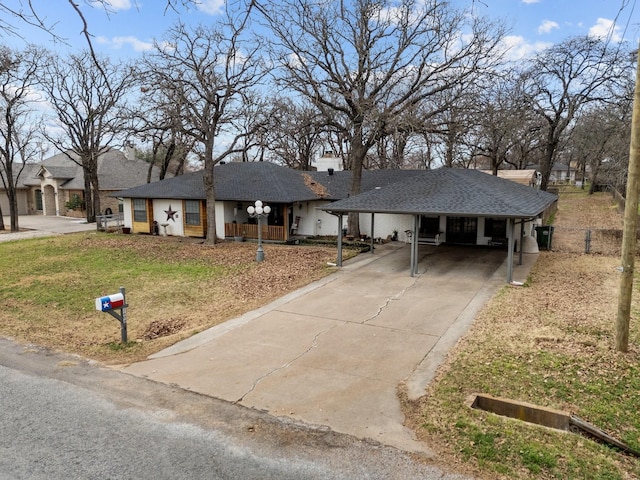 single story home featuring driveway, a front lawn, an attached carport, and roof with shingles