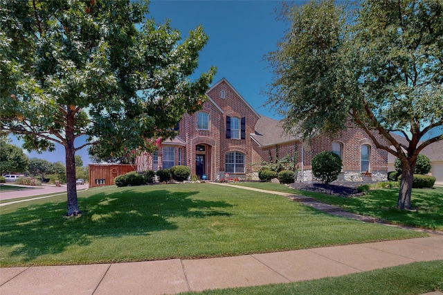 view of front facade with a front yard and brick siding