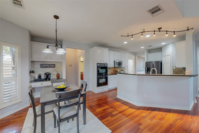 kitchen featuring appliances with stainless steel finishes, dark countertops, visible vents, and white cabinets