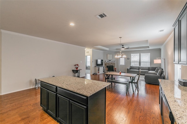 537 Running Water Trl, Fort Worth, TX 76131 - kitchen with a tray ceiling, ceiling fan, a center island, wood finished floors, and crown molding