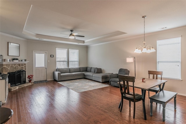 537 Running Water Trl, Fort Worth, TX 76131 - living area featuring a tray ceiling, dark wood-style flooring, ceiling fan, a stone fireplace, and ornamental molding