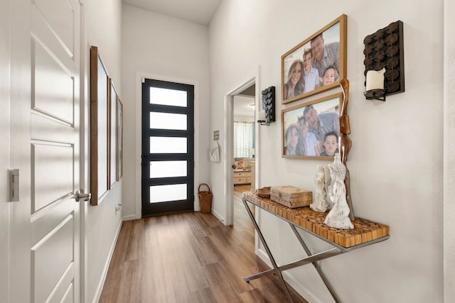 doorway featuring baseboards and wood finished floors