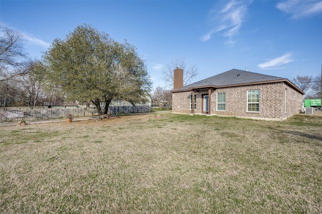 view of yard featuring fence and central AC