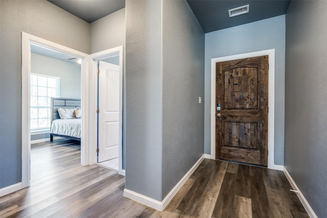 entryway featuring baseboards, visible vents, and wood finished floors