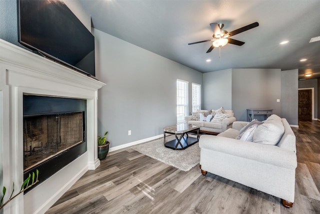 living area with a fireplace, recessed lighting, ceiling fan, wood finished floors, and baseboards