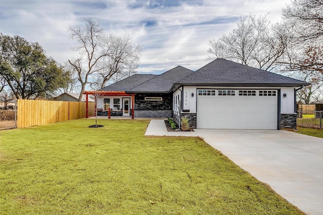 view of front of house with a garage, driveway, stone siding, fence, and a front yard