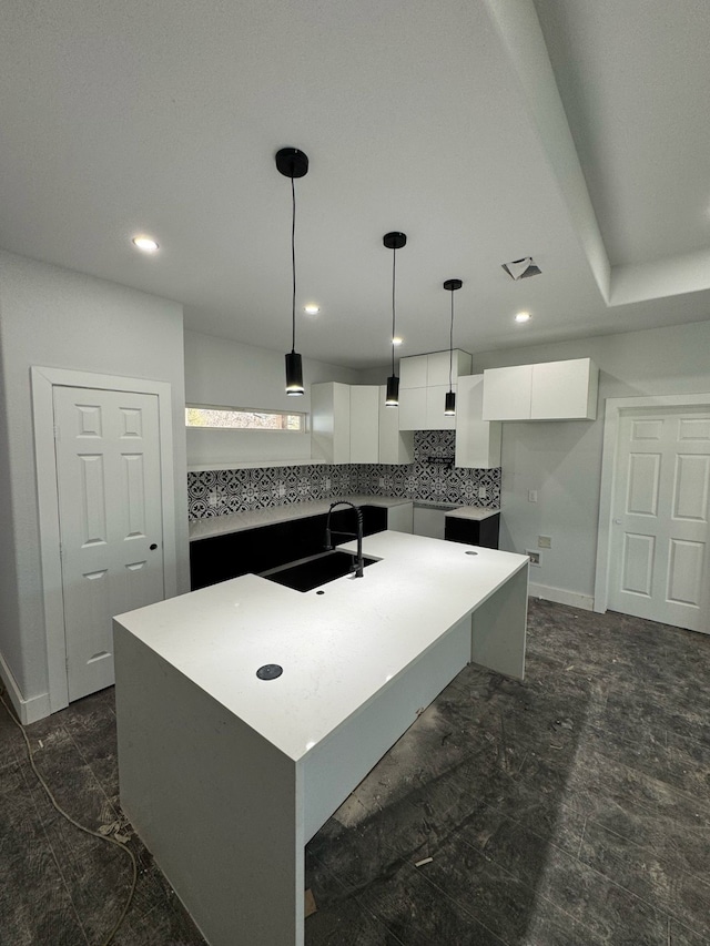 kitchen featuring pendant lighting, white cabinetry, a kitchen island, a sink, and modern cabinets