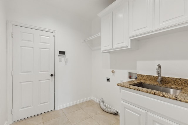 laundry area with cabinet space, light tile patterned floors, hookup for an electric dryer, washer hookup, and a sink