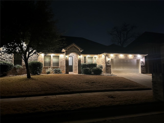 view of front of house featuring an attached garage, stone siding, and concrete driveway