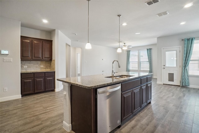 kitchen with a sink, a kitchen island with sink, pendant lighting, and stainless steel dishwasher