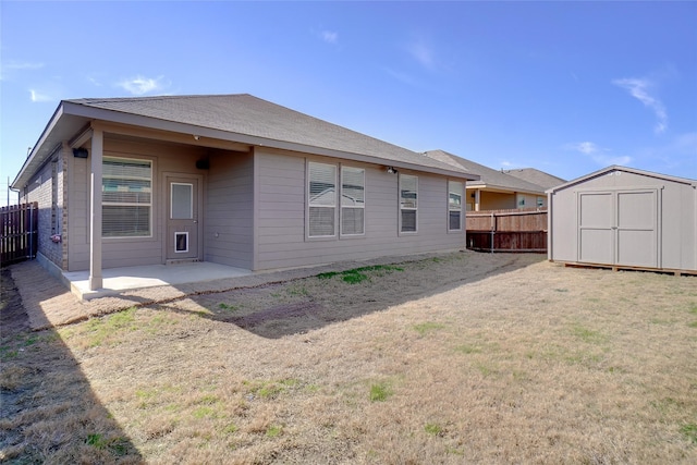 back of property with a patio, a storage unit, an outdoor structure, and a fenced backyard