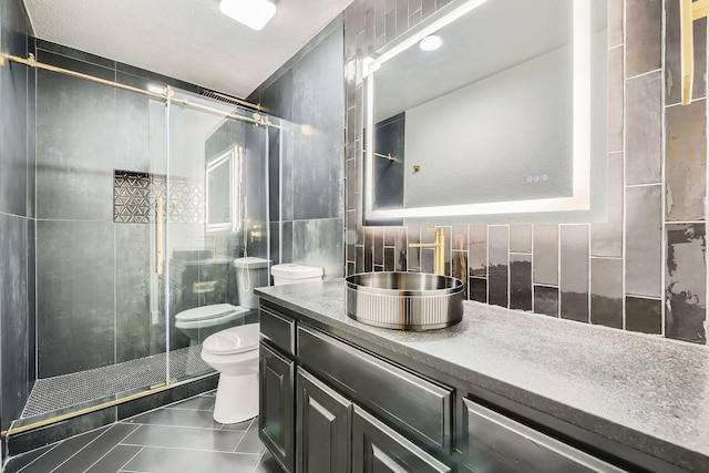 full bathroom featuring toilet, vanity, tile walls, backsplash, and a shower stall